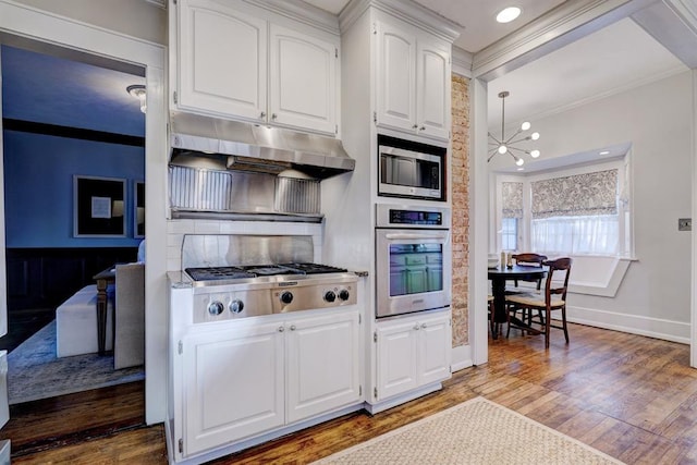 kitchen with crown molding, a chandelier, stainless steel appliances, light hardwood / wood-style floors, and white cabinets