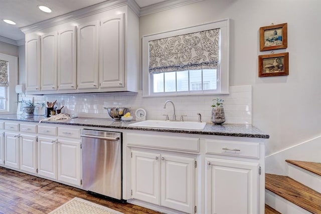 kitchen featuring dishwasher, white cabinetry, sink, backsplash, and dark stone counters