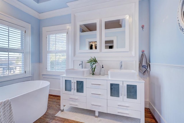 bathroom featuring crown molding, wood-type flooring, a bathing tub, and vanity