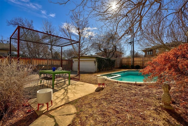 view of swimming pool with a garage and an outdoor structure