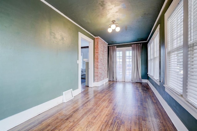 208 NW 20th St, Oklahoma City, OK 73103 - unfurnished room featuring ornamental molding, visible vents, baseboards, and wood finished floors