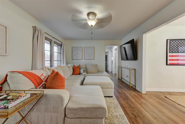 living room featuring wood finished floors, baseboards, and ceiling fan