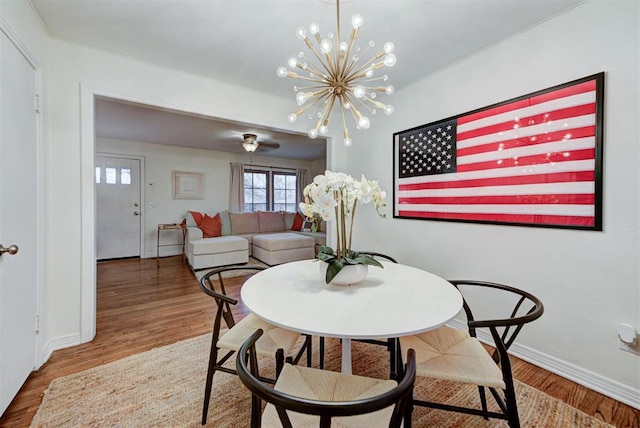 dining area with a chandelier, baseboards, and wood finished floors