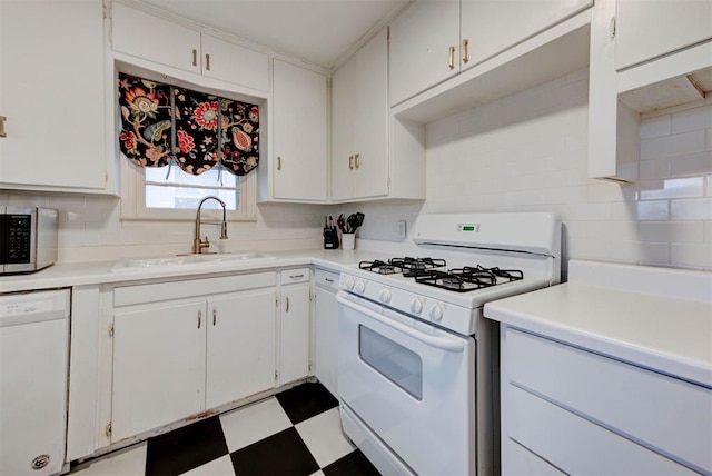 kitchen featuring white appliances, light countertops, tile patterned floors, and a sink