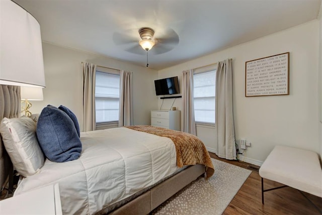 bedroom with a ceiling fan, baseboards, and wood finished floors