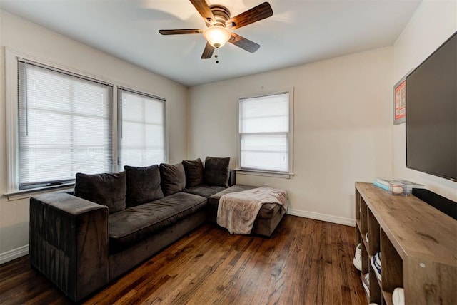 living room featuring baseboards, ceiling fan, and dark wood-style flooring