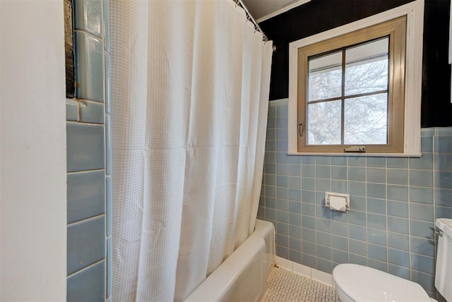 bathroom with tile patterned flooring, shower / bath combo with shower curtain, toilet, and tile walls