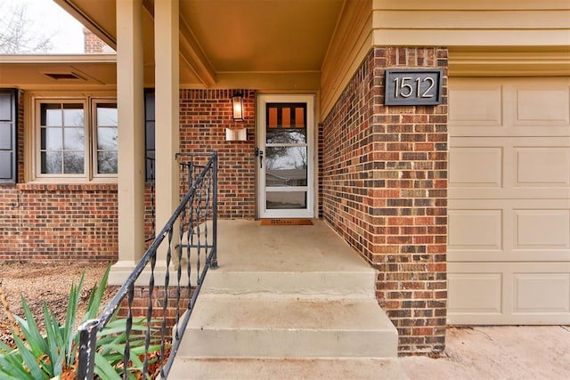 entrance to property with brick siding and an attached garage