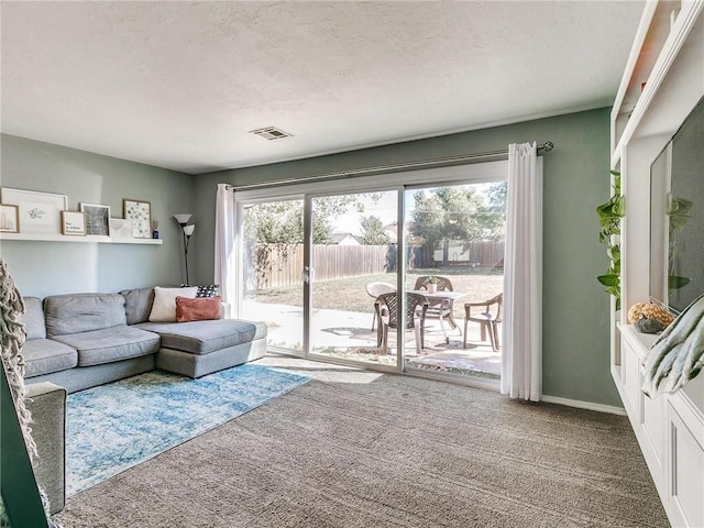 carpeted living room featuring a textured ceiling