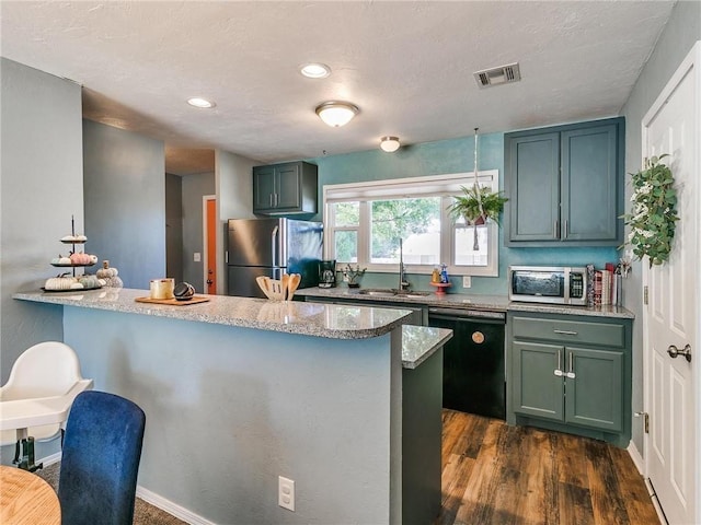 kitchen featuring dark hardwood / wood-style flooring, sink, stainless steel appliances, and light stone countertops