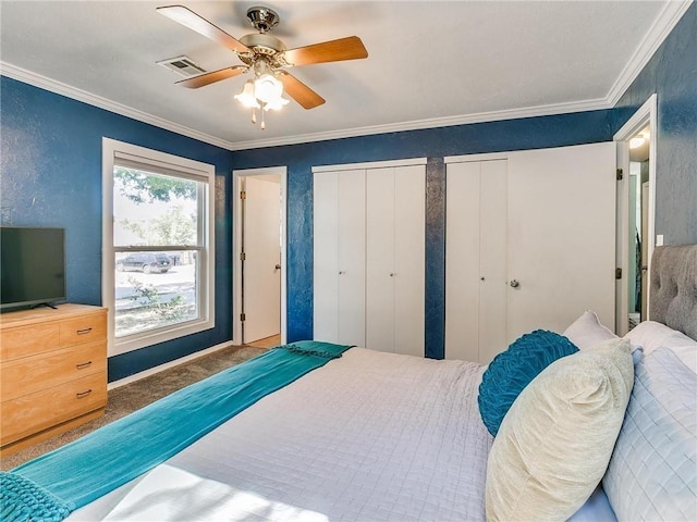 bedroom with multiple closets, ornamental molding, and ceiling fan