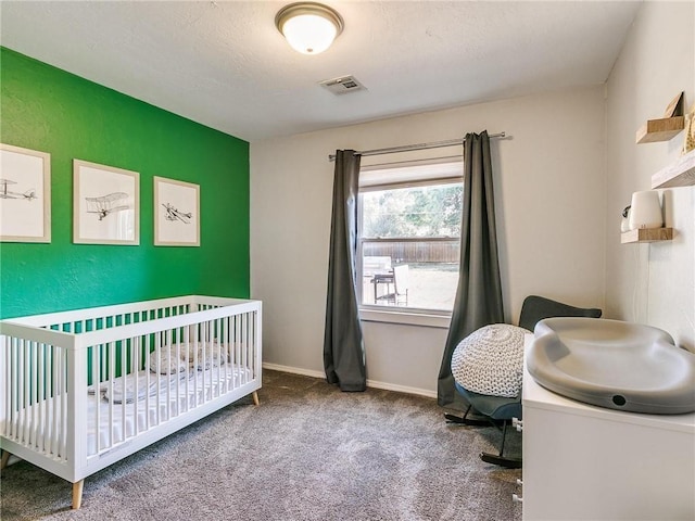 bedroom featuring a nursery area and carpet floors