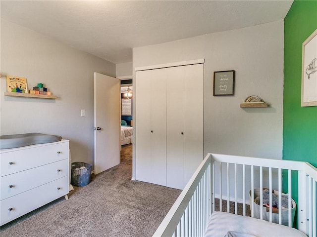 bedroom featuring light carpet, a crib, and a closet