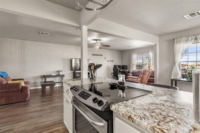 kitchen featuring light stone counters, dark hardwood / wood-style floors, ceiling fan, stainless steel electric stove, and white cabinets