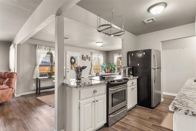 kitchen with appliances with stainless steel finishes, white cabinetry, light stone countertops, a healthy amount of sunlight, and dark hardwood / wood-style flooring