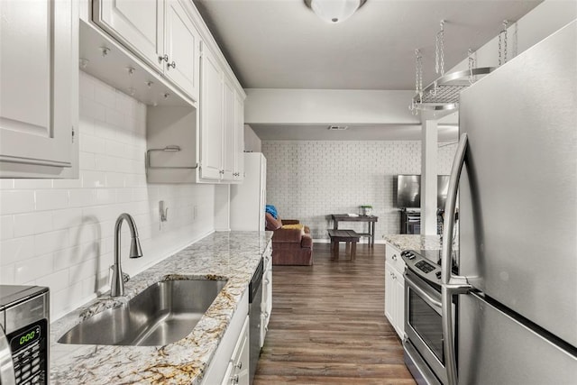 kitchen featuring sink, dark wood-type flooring, appliances with stainless steel finishes, light stone countertops, and white cabinets