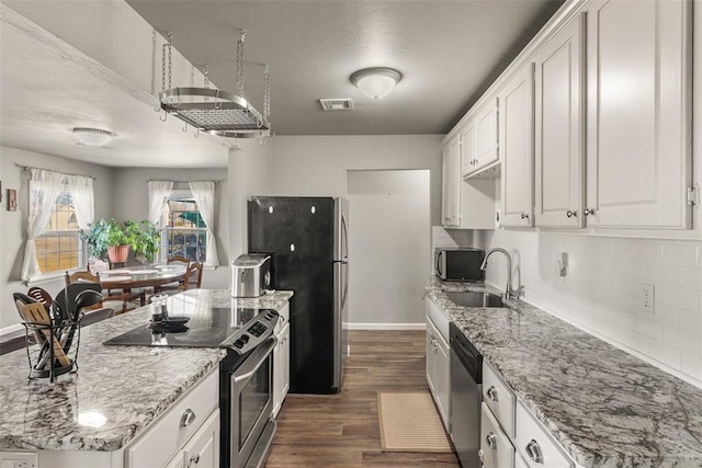 kitchen featuring white cabinetry, stainless steel appliances, light stone countertops, and sink