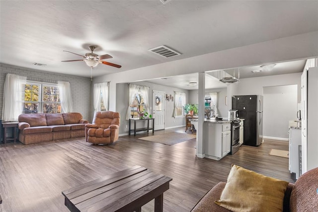 living room with ceiling fan, a healthy amount of sunlight, and dark hardwood / wood-style floors