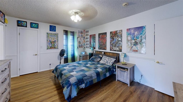 bedroom featuring a textured ceiling and dark hardwood / wood-style flooring