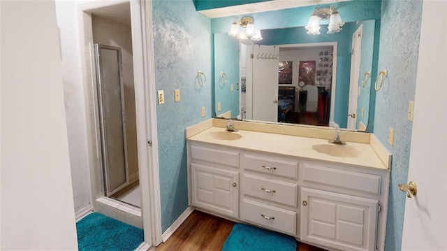 bathroom with a shower with door, vanity, and hardwood / wood-style floors