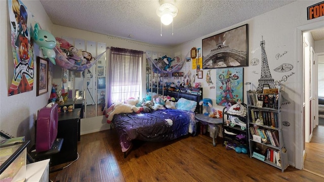 bedroom featuring hardwood / wood-style floors and a textured ceiling