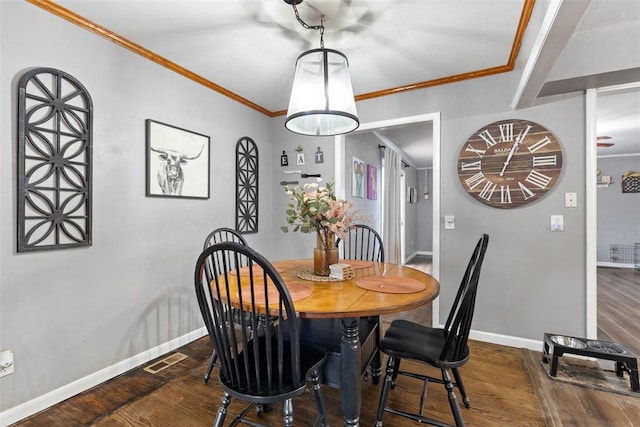 dining area featuring crown molding and dark hardwood / wood-style floors