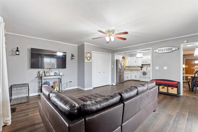 living room with dark wood-type flooring, ceiling fan, and crown molding