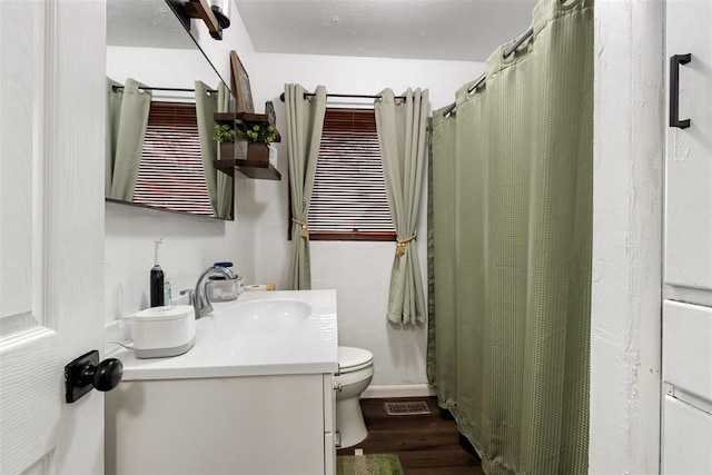 bathroom featuring vanity, wood-type flooring, and toilet