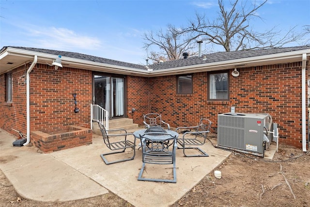 rear view of property with cooling unit and a patio