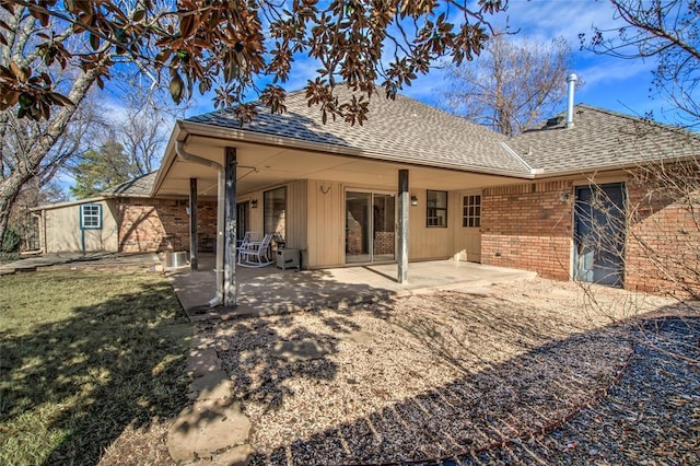 back of property featuring a patio area and a lawn