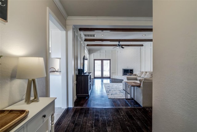 hallway featuring dark hardwood / wood-style floors, ornamental molding, beam ceiling, and french doors