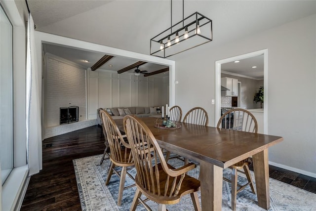 dining space featuring ceiling fan, a fireplace, dark hardwood / wood-style floors, and crown molding