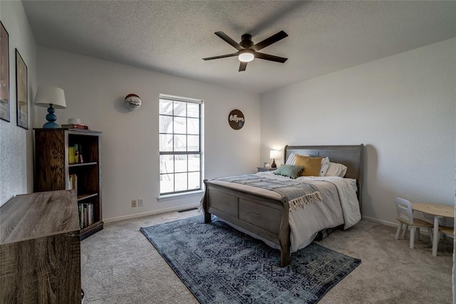 bedroom featuring ceiling fan, light colored carpet, and a textured ceiling