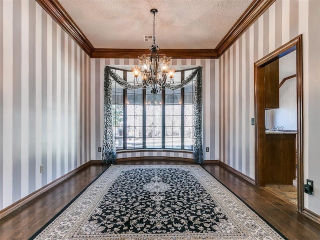 dining room with hardwood / wood-style flooring, crown molding, and a textured ceiling