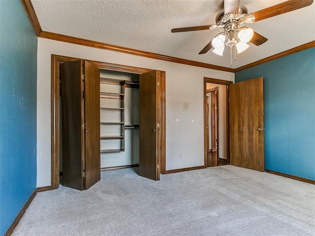 unfurnished bedroom featuring ornamental molding, ceiling fan, light carpet, a textured ceiling, and a closet