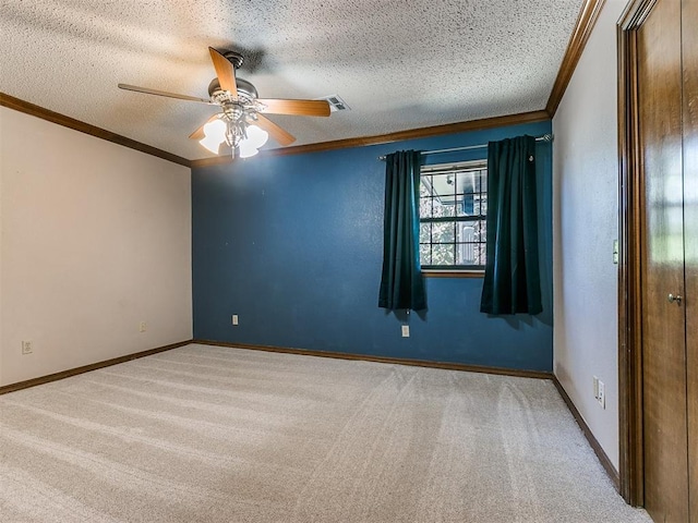 spare room featuring crown molding, light colored carpet, ceiling fan, and a textured ceiling