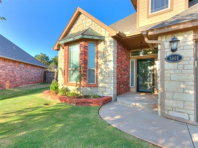 view of exterior entry featuring a yard