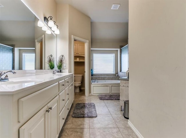 bathroom featuring vanity, tile patterned floors, a bathtub, and toilet