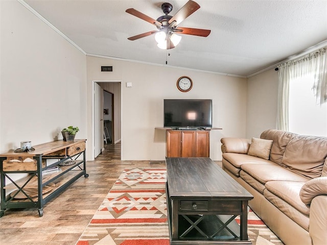 living room with hardwood / wood-style flooring, ornamental molding, ceiling fan, and a textured ceiling