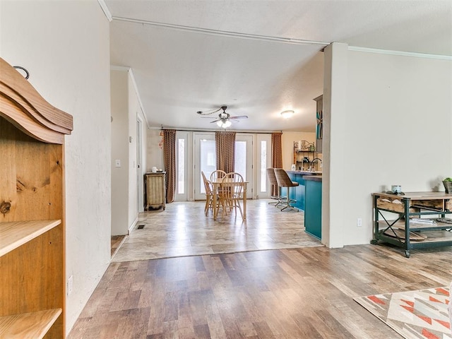 interior space with crown molding, light hardwood / wood-style flooring, and ceiling fan