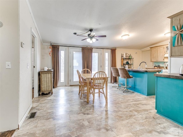 unfurnished dining area featuring vaulted ceiling, ceiling fan, and sink