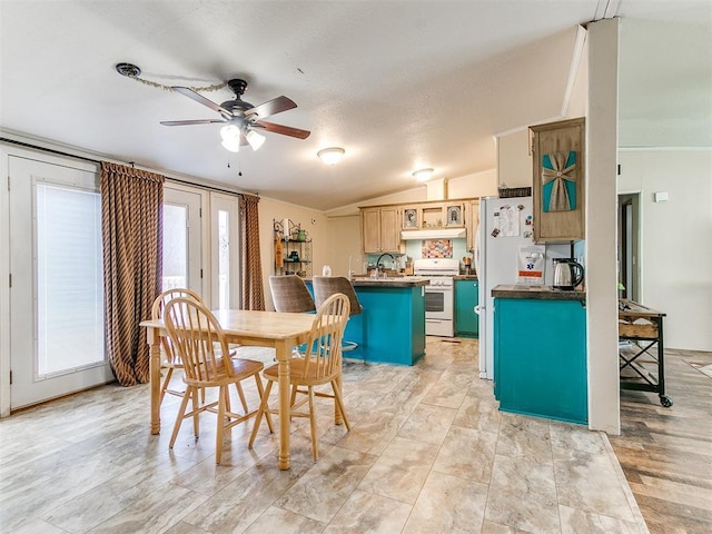 dining space featuring vaulted ceiling, sink, and ceiling fan