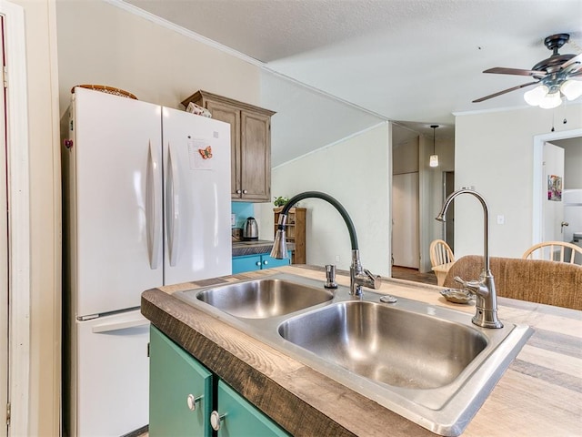 kitchen featuring sink, ceiling fan, ornamental molding, green cabinetry, and white fridge