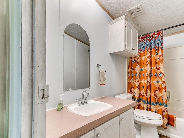 full bathroom featuring vanity, toilet, a textured ceiling, and shower / bathtub combination with curtain