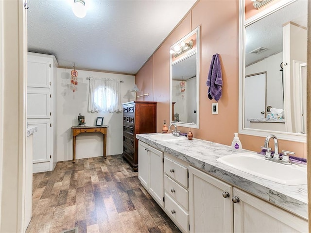 bathroom featuring vanity, hardwood / wood-style floors, and a textured ceiling