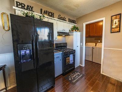 kitchen with dark wood-type flooring, separate washer and dryer, a textured ceiling, and black appliances