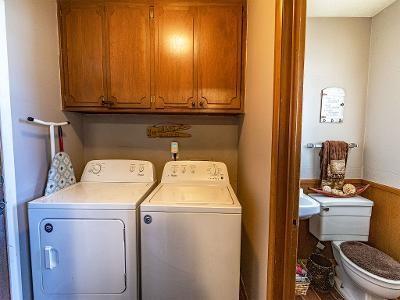 clothes washing area with cabinets and independent washer and dryer