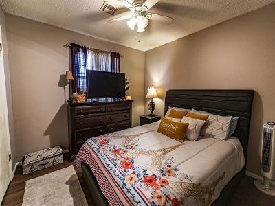 bedroom featuring ceiling fan, dark hardwood / wood-style floors, and a textured ceiling