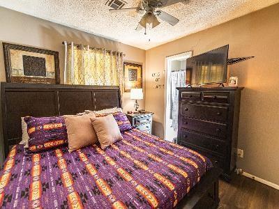 bedroom featuring ceiling fan, wood-type flooring, and a textured ceiling