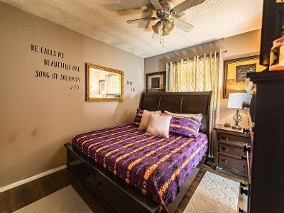 bedroom with ceiling fan, hardwood / wood-style floors, and a textured ceiling